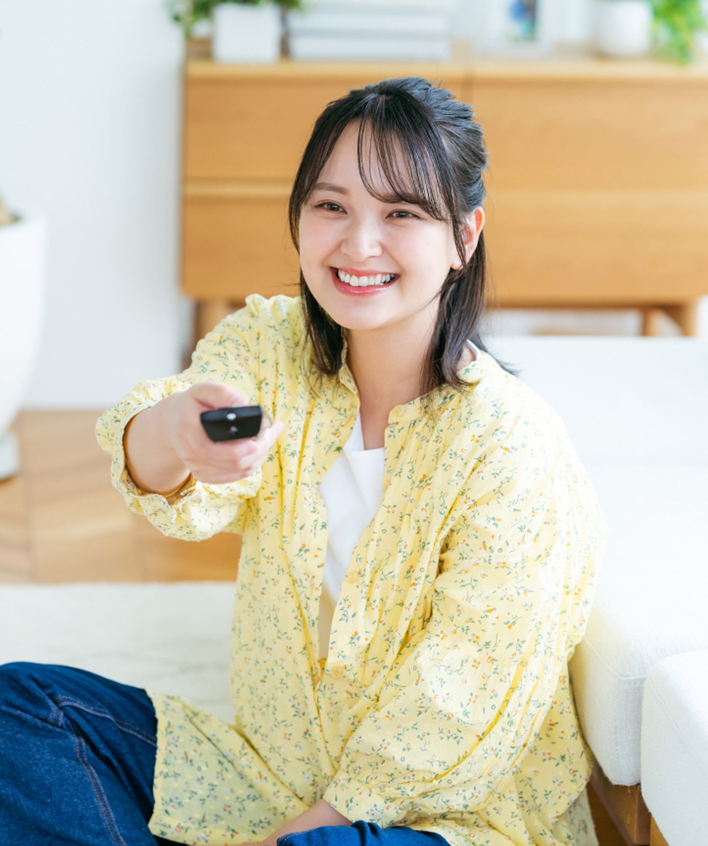 Woman smiling and using a tv remote