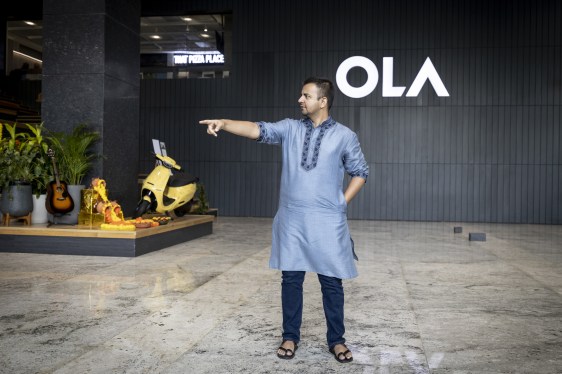 Man standing in front of Ola sign