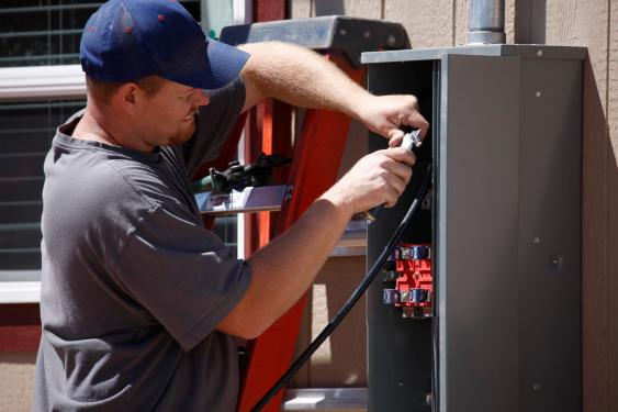 An electrician works on an electrical box.