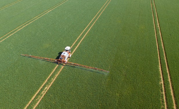 Crop sprayer in field, aerial view; agtech