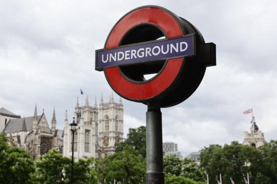 a photo of the London Underground sign with Westminister Abbey in London seen blurry in the background