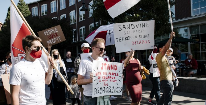 Demonstrators hold signs and wave Belarus flags during a protest outside Francisco Partners headquarters in San Francisco, California, U.S., on Friday, Sept. 18, 2020. The government of Belarus shut down access to much of the internet during a crucial election in August by using equipment manufactured by Sandvine Inc., the technology company backed by private equity firm Francisco Partners, to block people's access to thousands of websites.