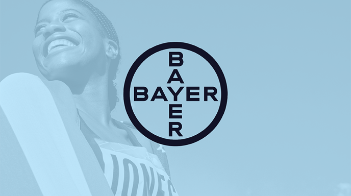 An olympian smiling and wrapped in the American flag with a blue overlay and the Bayer logo in the center
