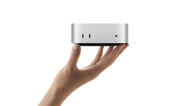 hand holding a Mac Mini on its fingertips